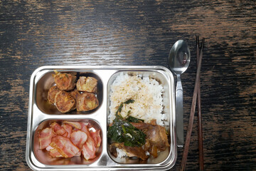 Lunch set in tray on wooden table.