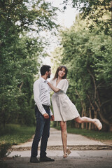 Fototapeta premium A guy and a girl are walking in the park. Romantic date evening walk. The relationship between people is love and tenderness.