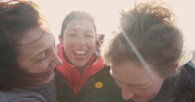 MS Three female hikers embracing and smiling in landscape / Yorkshire Moors, Yorkshire, UK