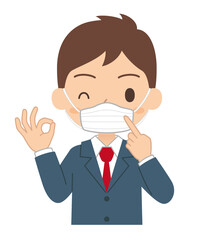 マスクを指してOKサインをする男子学生