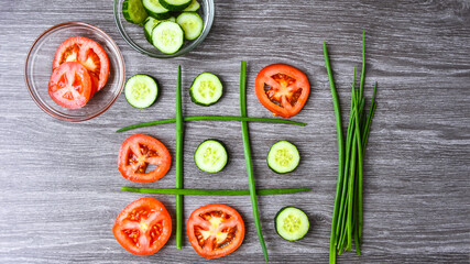 Diet concept hazardous game for health tic tac toe made of tomatoes cucumbers and green onion