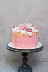 Birthday pink cake for a little girl with fondant crown, melted chocolate, meringue and cake pops...