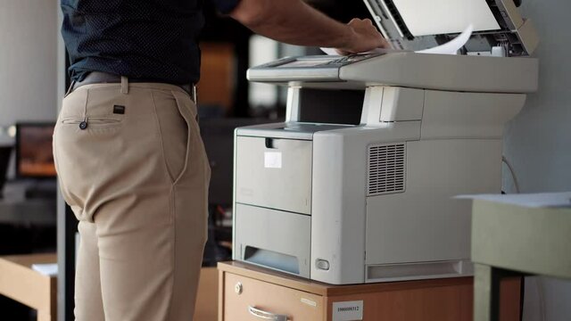 Man Finger Press Buttons On Multifunctional Copier.Man Using Printer Or Scanner In Office.Businessman Printing Document On Workplace.Businessman Working In Office And Preparing Documents For Signature