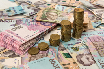 Close up coin stacked growing as financial  chart lying on ukraine money as background. For business growth