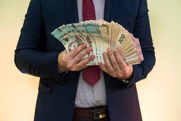 Male hands holding stack of ukrainian hryvnia banknotes isolated on green. Hryvnia new 1000 500 and 200 uah banknotes.