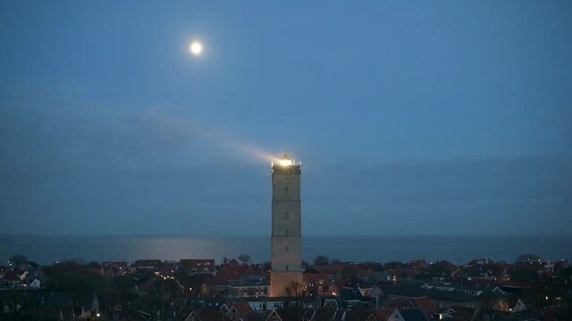 WS View of seaside village and illuminated Brandaris lighthouse at night  / Terschelling, Friesland, Netherlands