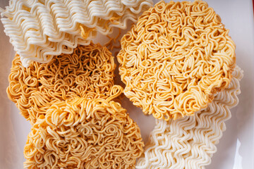 Top view - Many type of instant noodles on white plate over red background.