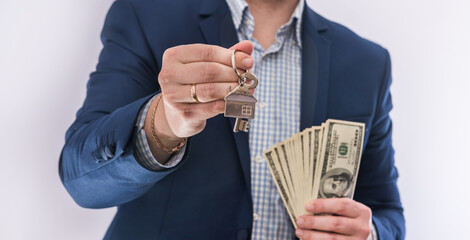 Male hands  holding US dollars bills and house key isolated