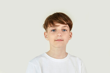 Beautiful cute boy in a white T-shirt on a white isolated background.
