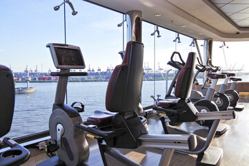 Staying fit and healthy with cardio fitness equipment, treadmills and free weights in gym or...