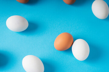 Brown and white eggs over blue background.