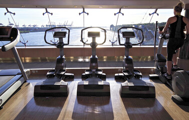 Staying fit with cardio fitness equipment, treadmills and free weights in gym or fitness center on...