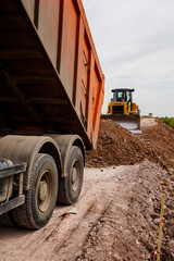truck pours clay from the body, road repairs, road works, vehicles © Aleksey