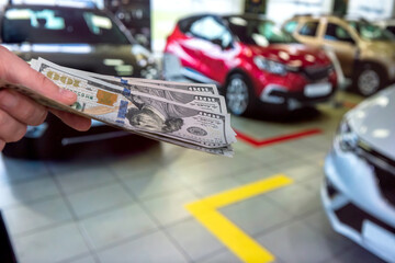  Man with 100 dollar banknotes money near car. Buy or rent a new auto