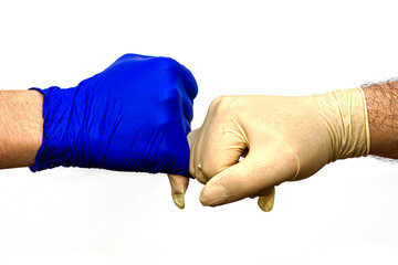 hands in blue and white protective surgical gloves greet each other with little fingers.