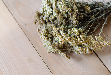 Dried yarrow flowers for use in alternative medicine, Ayurveda, naturopathy on a white wooden table. Summer flat lay. High quality photo