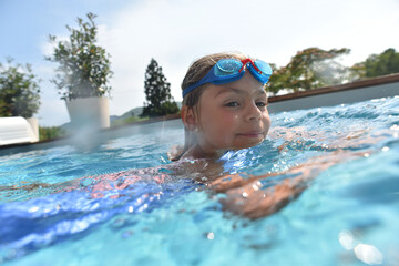Little girl in private swiimming-pool wearing goggles