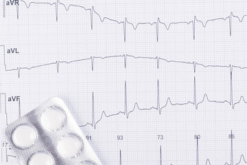 heartbeat paper with white pills, black and white background, top view