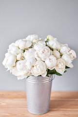 White Odile peonies in a metal vase. Beautiful peony flower for catalog or online store. Floral shop concept . Beautiful fresh cut bouquet. Flowers delivery. Copy space