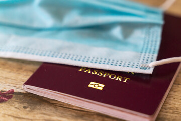 passport and face mask on table, travel during pandemic concept.