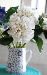 Beautiful white and blue imitation hydragrea flowers in blue and white vase