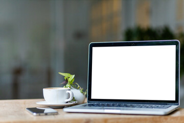 Mockup of laptop computer with empty screen with coffee cup and smartphone on table of the coffee...