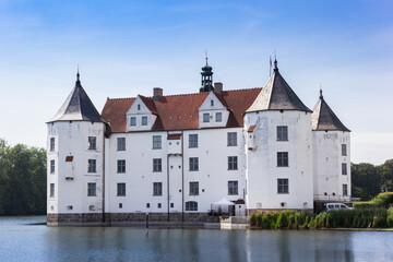 Fototapeta na wymiar Historic white castle at the lake in Glucksburg, Germany
