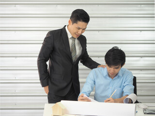 Asian businessman and architect or engineer are discussing work together in office.