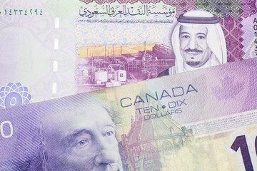A close up macro shot of a purple ten Canadian dollar bill with a five riyal note