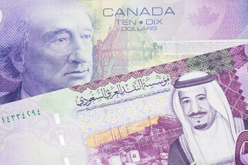 A close up macro shot of a purple ten Canadian dollar bill with a five riyal note