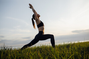 a sporty girl does yoga in the Park. Outdoor sports activities