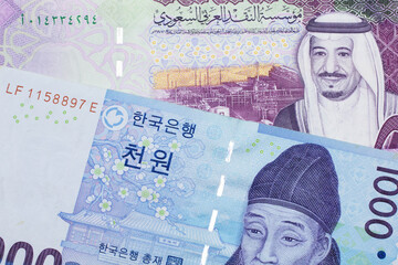 A blue two thousand won note from South Korea close up in macro with a five riyal note from Saudi Arabia