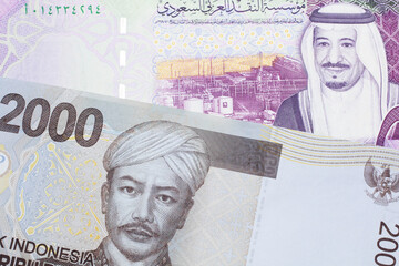 A gray two thousand Indonesian rupiah bank note with a five Saudi riyal note 