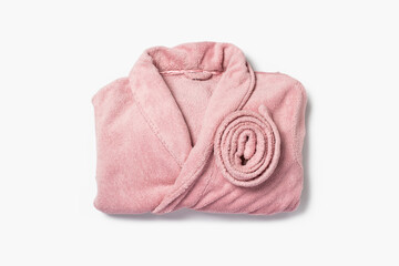 Female pink bathrobe neatly folded on a white background. Copy space, flat lay