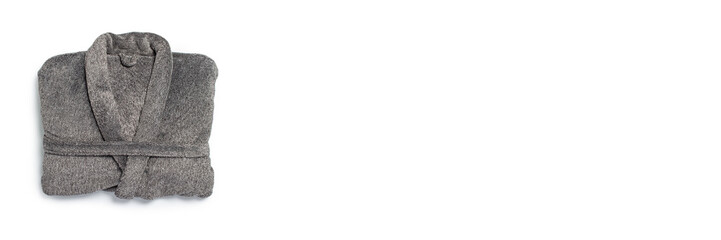 Male gray bathrobe neatly folded lies on a white background. Copy space, flat lay. Banner