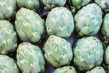 Obraz premium Green artichoke vegetables background, top view, close up