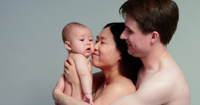 SLO MO CU Studio shot of parents with baby son (6-11 months)
