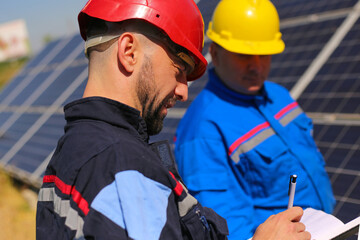 Green energy, two technicians control solar panels