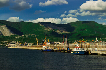 Tugboats at the pier in the port of Novorossiysk on a sunny day.