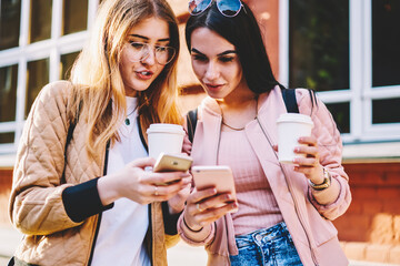 Cheerful female best friends using 4G internet connection outdoors for uploading map of city