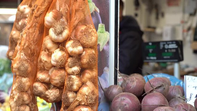 CU Fresh garlic in mesh bags in farmer's market / Norwich Market, Norfolk, United Kingdom