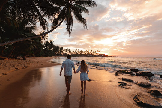 Happy Romanticjust married travel Couple Enjoying Beautiful Sunset Walk on the Beach. Travel Vacation Retirement Lifestyle Concept