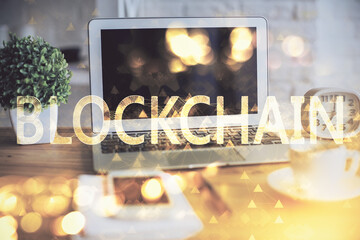 Multi exposure of blockchain and crypto economy theme hologram and table with computer background....