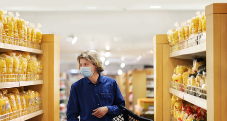 Supermarket shopping, face mask and gloves,Young man shopping in supermarket, reading product information