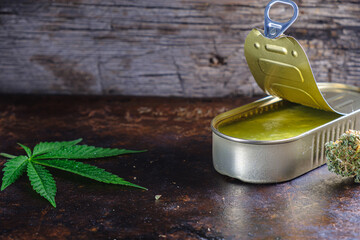 marijuana buds. medical cannabis butter in a open tin can. hemp leaves. horizontal orientation.