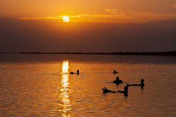 People floating at the Dead sea at dawn, Israel