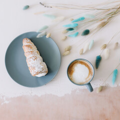 breakfast with bakery and coffee. Puff rolls with cream on a plate and cappuccino. Top view