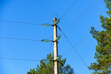 Obraz premium The power line support changes the direction of the electric wires against the blue sky