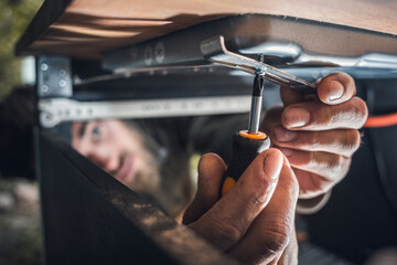 Hands of a mechanic with a screwdriver in a narrow space