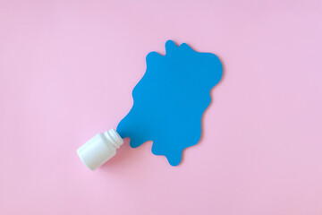 White pill packaging with blue paper splash on pink background. Medicine concept. 